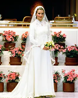Expressions Prints: 1970s 1980s SMILING BRIDE IN GOWN LOOKING AT CAMERA HOLDING YELLOW BOUQUET LONG VEIL LACE TRIM STANDING BY TIERS OF