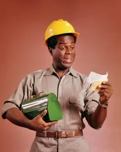 Expressions Prints: 1970s AFRICAN AMERICAN WORKMAN HOLDING LUNCHBOX AND PAYCHECK SMILING WEARING A YELLOW HARD HAT