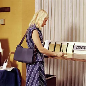 Banking Prints: 1970S Blond Woman Writing A Deposit Slip At Counter In Bank