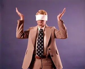 Oldtime Prints: 1970s EXECUTIVE MAN WEARING BUSINESS SUIT WEARING BLINDFOLD HOLDING BOTH HANDS UP IN HOPELESS GESTURE