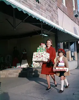 Daughters Prints: 1970S Mother And Daughter Carrying Stacks Of Gift Packages