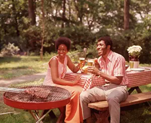 Grownup Prints: 1970s SMILING AFRICAN AMERICAN COUPLE MAN WOMAN DRINKING BEER AT BACKYARD BARBECUE