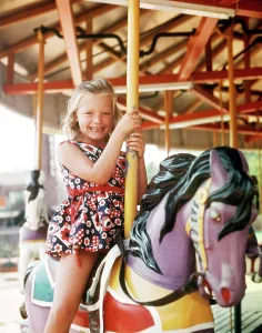 Oldtime Prints: 1970s SMILING GIRL PRINT DRESS SITTING CAROUSEL HORSE HOLDING POLE MERRY-GO-ROUND AMUSEMENT PARK RIDE