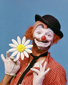 Expressions Prints: 1970s SMILING WIDE-EYED WHITE FACE HOBO CLOWN WITH RED NOSE LOOKING AT CAMERA WEARING A DERBY HAT AND HOLDING A PAPER