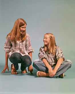 Oldtime Prints: 1970s TWO TEEN GIRLS SISTERS WEARING BLUE JEANS DENIM PEASANT SHIRTS SITTING AND KNEELING SMILING LOOKING AT EACH OTHER