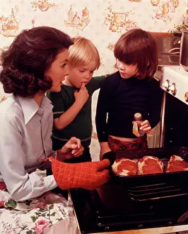 Oldtime Prints: 1970s WOMAN MOTHER 2 CHILDREN BOY GIRL KITCHEN OVEN DOOR OPEN CHECKING STEAKS MEAT ADDING SPICE COOKING