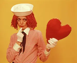 Oldtime Prints: 1970s YOUNG WOMAN RAGGEDY ANN WIG COSTUME SAILOR HAT YELLOW BACKGROUND HOLDING UP HEART