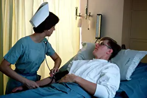 Archives Prints: 1977 - A US Army nurse takes a patient's blood pressure
