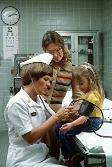 Archives Prints: 1977 - A nurse takes a child's blood pressure