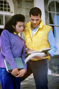 Sweater Prints: 1980s AFRICAN AMERICAN COLLEGE COUPLE LOOKING AT TEXTBOOK