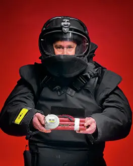 Mystery Prints: 1990s MAN BOMB SQUAD TECHNICIAN LOOKING AT THE CAMERA HOLDING A BOMB STICKS OF EXPLOSIVE WITH WIRES AND TIMER ATTACHED