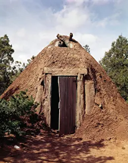Arizona Prints: 2000s NAVAJO HOGAN CONE SHAPED BUILDING BUILT OF LOGS MUD DIRT EARTH FRONT DOOR FACES EAST NATIVE AMERICAN DWELLING