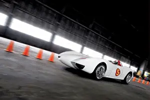 Cars Prints: Front 3/4 action view of Speed Racer's Mach 5 race car inside a secret location warehouse