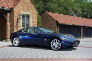 Asphalt Prints: Front 3/4 static view of a blue 2010 Maserati GranTurismo in front of a private upscale garage