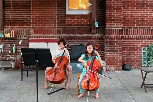 Brick Prints: Above-view of two children sitting on patio playing cello