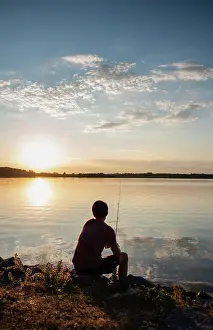 14 16 Years Old Prints: Adolescent boy fishing on shore of lake at sunset in Ontario, Canada