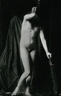 An adolescent girl, posing naked leaning on the back of a chair
