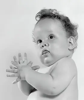 Charming Prints: Adorable baby in black and white portrait with curly hair and curious expression