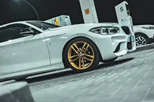 Sleek Prints: Adria, Italy 30 july 2024: View of a BMW Series 1 with gold wheels parked at night