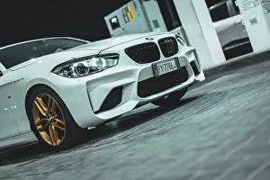 Sleek Prints: Adria, Italy 30 july 2024: View of a BMW Series 1 with gold wheels parked at night