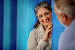 Celebrations Prints: AN ADULT WOMAN LOVINGLY LOOKING AT HUSBAND WHILE STANDING BEHIND A WALL