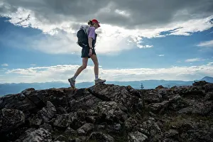 Adventurous Solo Hiker Exploring Rocky Mountain Trail Under a Majestic Sky