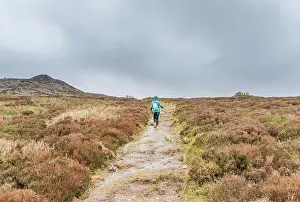 Mountain Climbing Prints: Adventurous Woman Hiking Rain-Soaked Trail