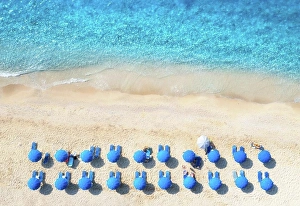 Parasol Prints: Aerial view of blue sea, sandy beach with sun beds and umbrellas at sunset in summer