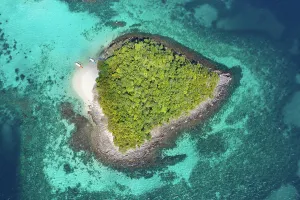 Azure Prints: Aerial view of boats beside small green tropical island among azure water of ocean