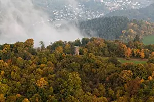 Hills Prints: Aerial view of Dronke tower amidst autumnal trees and rising fog