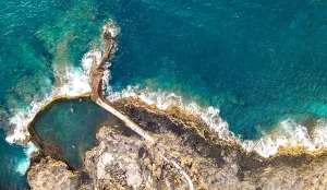 Canary Islands Prints: aerial view of natural pool near to the alantic ocean with 3 person