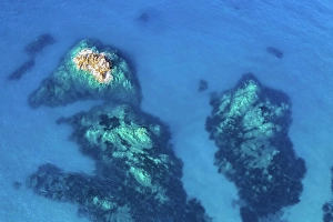 Drone Shot Prints: Aerial view of rocks beneath crystalclear blue waters