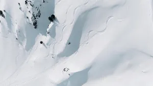 26 29 Years Old Prints: Aerial view of ski tracks and a freeskier on a snowy mountain slope
