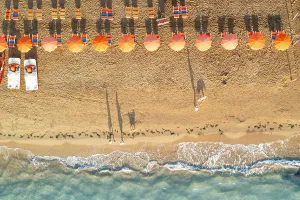 Apulia Prints: Aerial view of sunshades in a row on sand beach washed by the crystal sea
