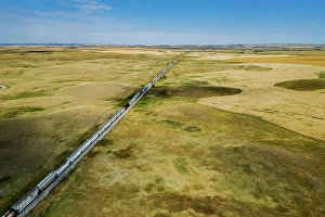 Crops Prints: Aerial view of a train traveling through farmer's fields in a southern Saskatchewan prairie near Moose Jaw