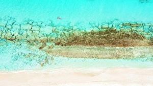 West Indies Prints: Aerial view of woman floating on the crystal sea in between coral reef and white sand beach