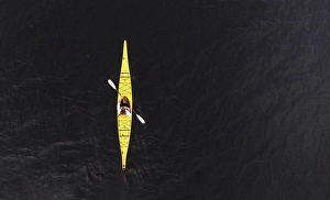 Kayak Prints: Aerial view of woman paddling yellow kayak on dark lake water