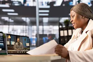 Financial Prints: African american businesswoman in online videocall with client