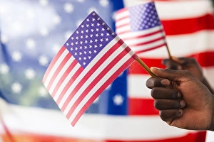 Stripes Prints: African American hand holding an American flag with another flag in the background