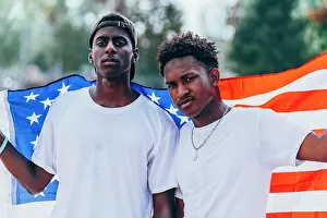 Uniqueness Prints: Serious African American men holding American flag on shoulder and looking away