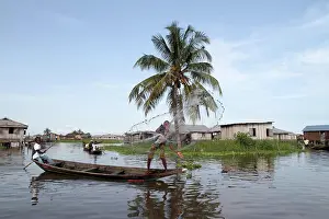 West Africa Prints: African children fishing with a net from a canoe