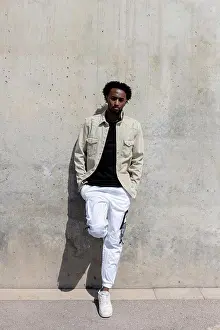 Trendy Prints: Afro man leaning on concrete wall with hands on pocket