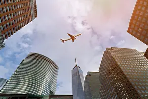 Financial Prints: Airplane flying over over city buildings in downtown skyscrapers over Manhattan