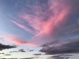 Luminous Prints: Above Altostratus Cirrus clouds are illuminated pink by the setting sun