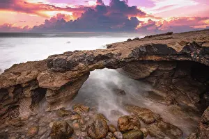 Cliffs Prints: Arch shaped rock formation in the coastline at the sunset