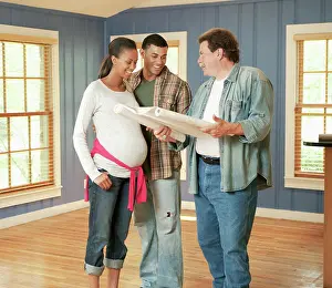 Conversation Prints: Architect reviewing blueprints with couple