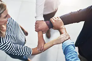 Partnership Prints: Arms, huddle and unity with team of business people in office from above for solidarity or support