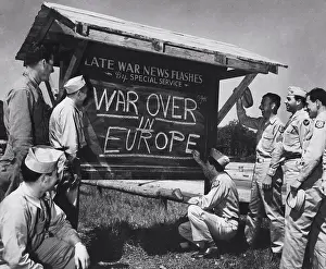 Ww Ii Prints: An Army private is shown breaking the news of the end of the war in Europe to other Soldiers after receiving an