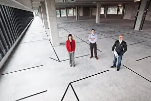 Bald Prints: Asian architect with Caucasian man and woman business people in a new raw business space