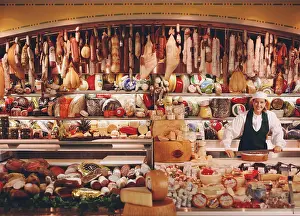 Cheese Prints: Associate in Chefs hat at deli counter with large selection of imported meats and cheeses
